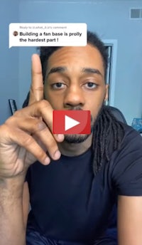 a man with dreadlocks making a finger gesture